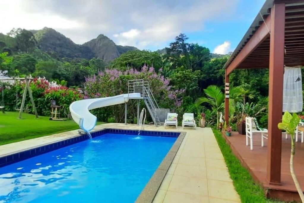 a swimming pool with a water slide in a backyard at Sítio recanto do Saltinho Santa teresa -ES in Santa Teresa