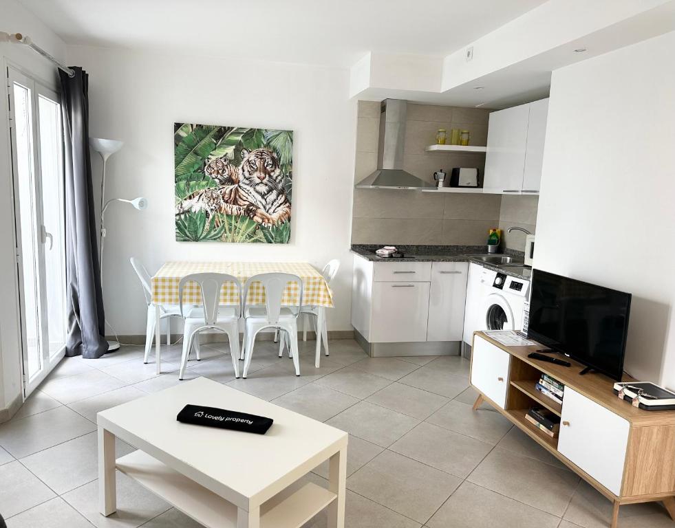 a living room with a table and a kitchen at Banana Cake - piscina, doble terraza, última planta , wifi y parking in Corralejo