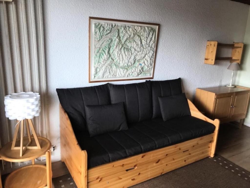 - un canapé avec des coussins noirs dans le salon dans l'établissement Résidence Serac - 2 PIECES CABINE POUR 4 PERSONNES EXPOSE SUD AU SEIN DU QUARTIER SLALOM MAE-7577, à Val Thorens