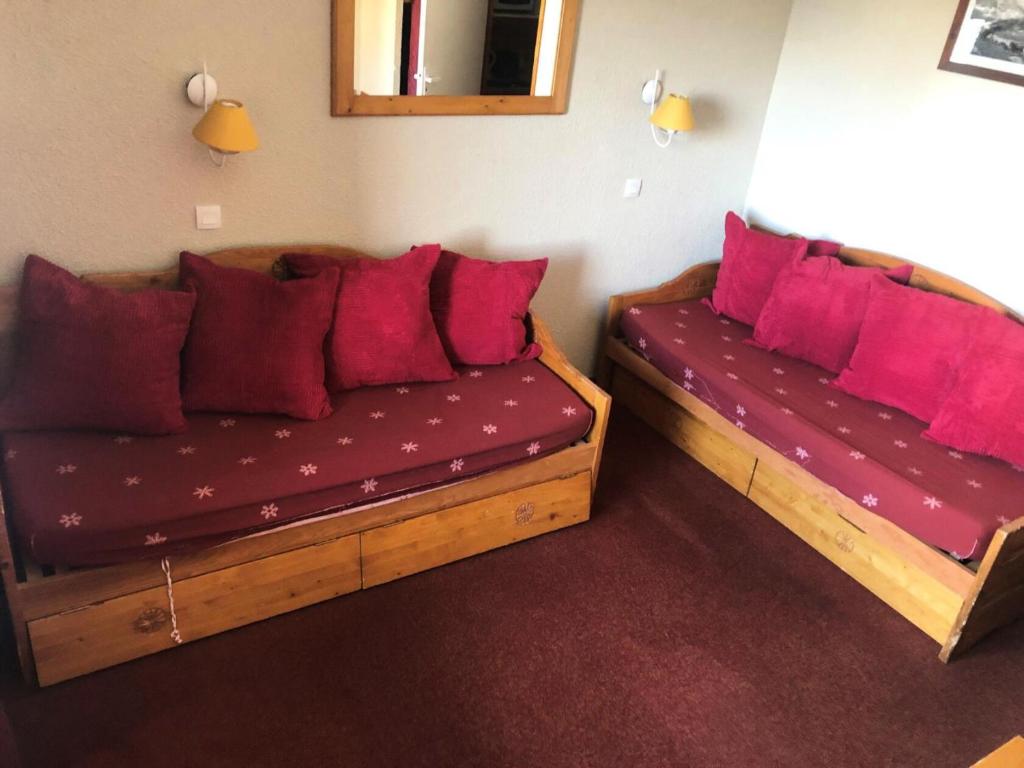 deux lits dans une chambre avec des oreillers rouges dans l'établissement Résidence Temples Du Soleil Cuzco - TEMPLES DU SOLEIL CUZCO STUDIO CABINE 23M² 4 PERS FONCTIONNEL PIED DES PISTES MAE-7619, à Val Thorens