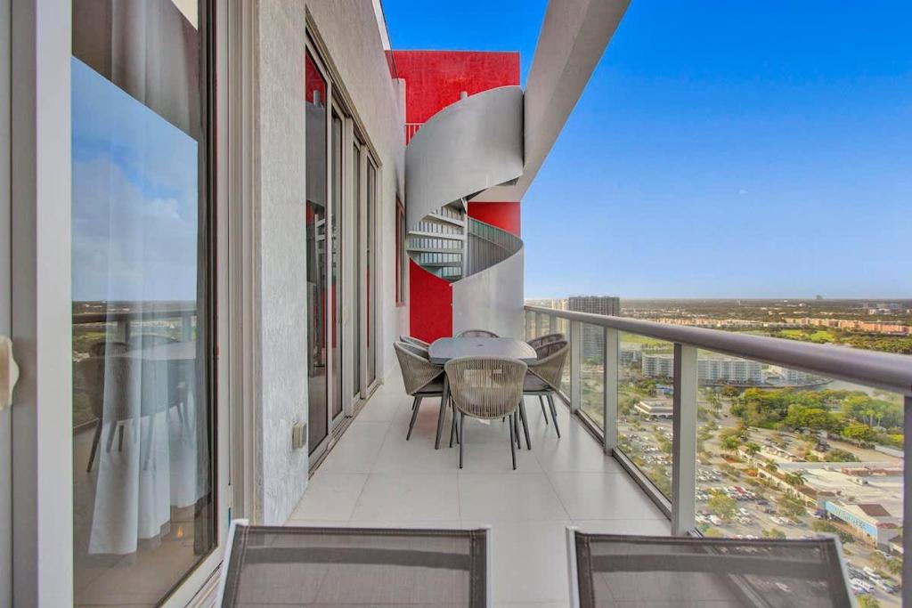 a balcony with a table and chairs on a building at Penthouse Sky Suite - 2BDR2BTH - Private Rooftop Terrace in Hallandale Beach