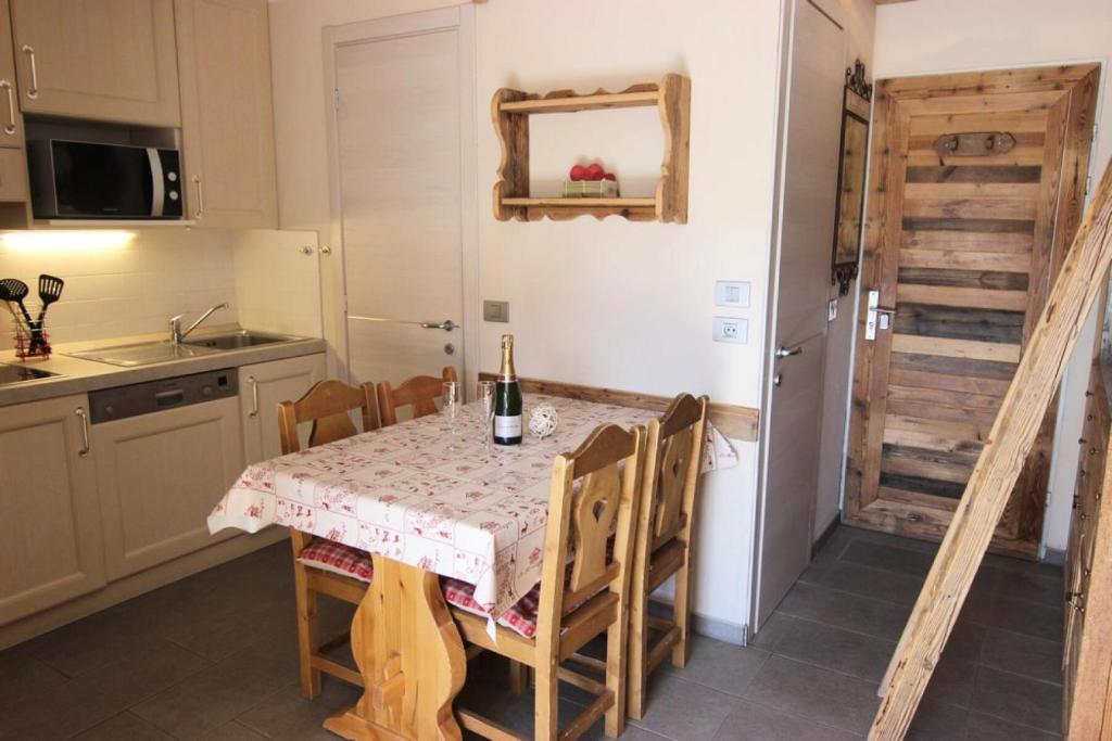Il comprend une cuisine équipée d'une table et de chaises. dans l'établissement Résidence Altineige - ALTINEIGE STUDIO CABINE 25M² 4 PERS STYLE CHALET MAE-7682, à Val Thorens