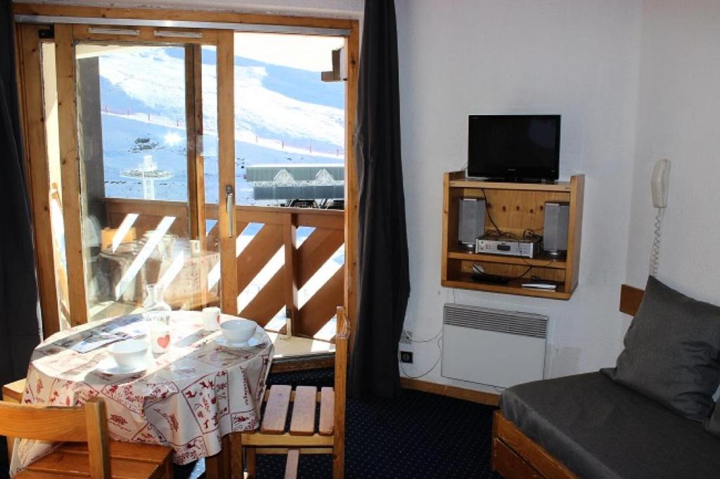 Cette chambre dispose d'une table et d'un balcon avec une télévision. dans l'établissement Résidence Temples Du Soleil Machu - VAL THORENS 2 PIECES 4 PERSONNES AU PIED DES PISTES ET EXPOSE SUD MAE-7683, à Val Thorens