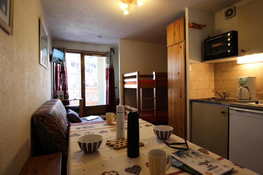 une petite cuisine avec une table et une cuisine gmaxwell gmaxwell gmaxwell gmaxwell dans l'établissement Résidence Cimes De Caron - CIMES DE CARON STUDIO CABINE 24M² 4 PERS MAE-7709, à Val Thorens