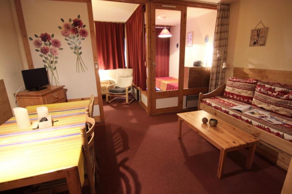 a living room with a table and a mirror at Résidence Eskival - ESKIVAL APPARTEMENT 35M² 4 PERS CENTRE STATION ACCES DIRECT SUR LES PISTES MAE-7717 in Val Thorens