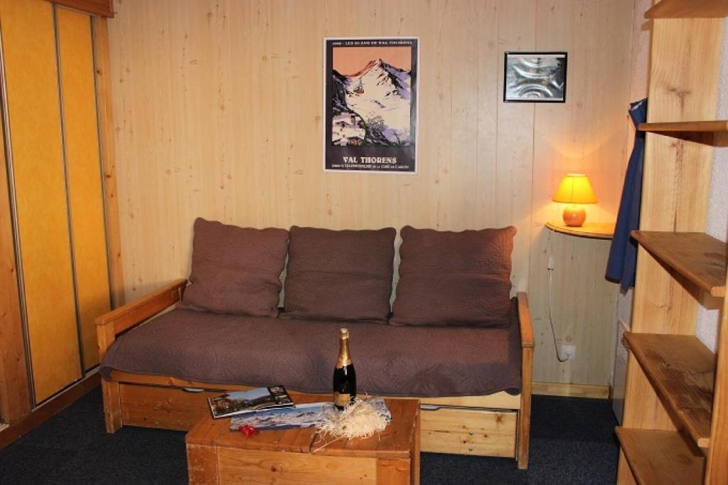 - un salon avec un canapé et une bouteille de champagne dans l'établissement Résidence Orciere - 2 PIECES CABINE POUR 4 PERSONNES AVEC BALCON MAE-7747, à Val Thorens