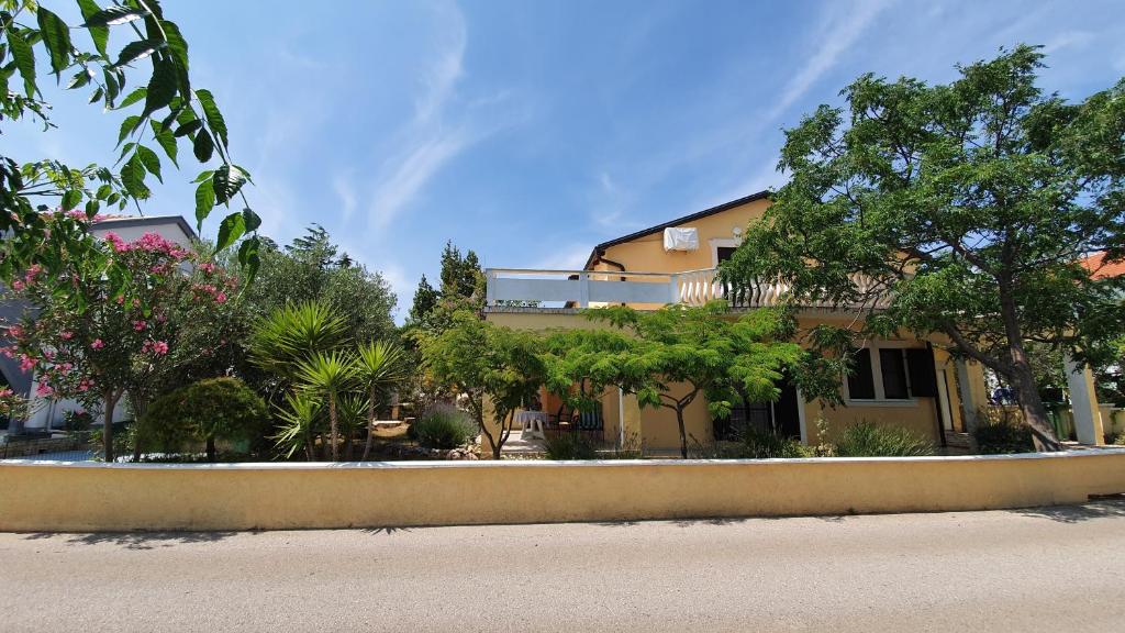 a house with trees in front of a street at Tuan Vir Apartment in Vir