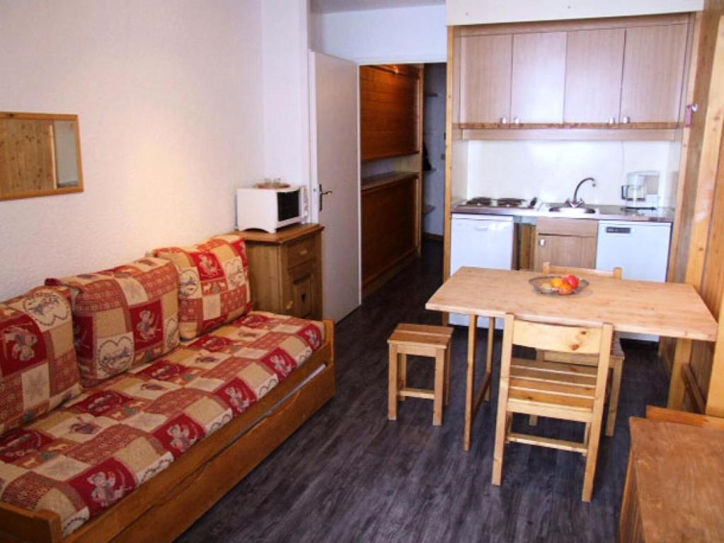 Cette chambre dispose d'un canapé, d'une table et d'une cuisine. dans l'établissement Résidence Hauts De Vanoise - VAL THORENS STUDIO 3 PERSONNES FONCTIONNEL ET PROCHE DE TOUT MAE-7750, à Val Thorens