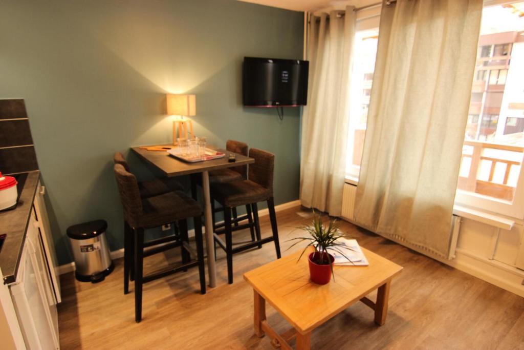 Elle comprend un petit salon avec une table et un bureau. dans l'établissement Résidence Hauts De Chaviere - HAUTS DE CHAVIERE STUDIO 23M² 4PERS PLACE SLALOM DECO MODERNE MAE-7772, à Val Thorens