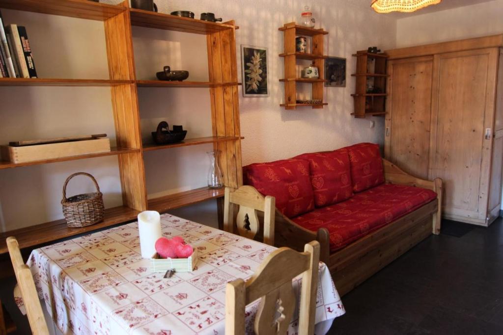 un salon avec un canapé rouge et une table dans l'établissement Résidence Cimes De Caron - CIMES DE CARON STUDIO 21M² 3 PERS JOLIE VUE MAE-7765, à Val Thorens