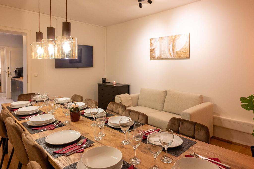 Hotel Munich Large Apartment 110 qm, 3 Bedrooms and very Central 1-12 Guests, a dining room with a table and a couch at Munich Large Apartment 110 qm, 3 Bedrooms and very Central 1-12 Guests in Munich