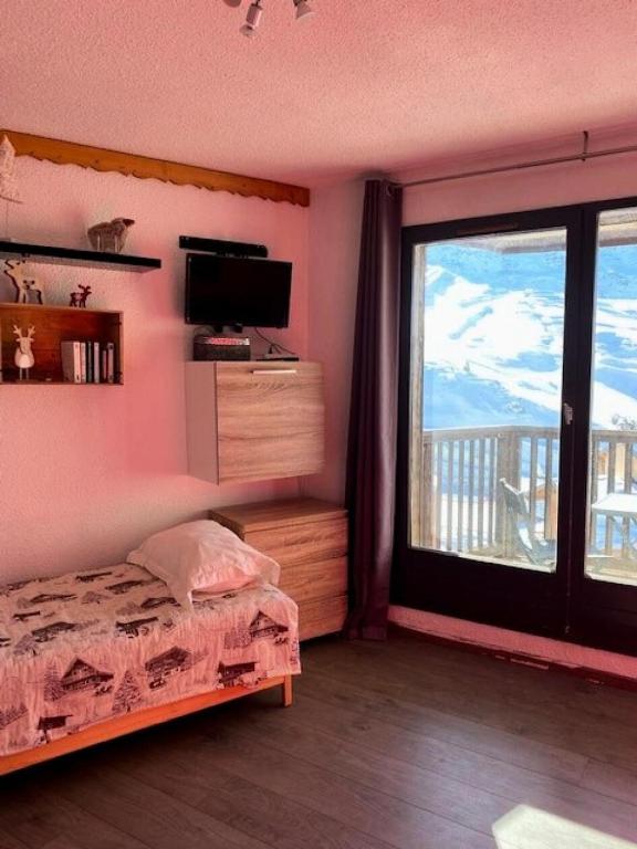 une chambre avec un lit et une grande fenêtre dans l'établissement Résidence Cimes De Caron - CIMES DE CARON STUDIO 19M² 3 PERS JOLIE VUE MONTAGNE MAE-7777, à Val Thorens
