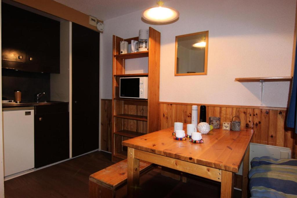 een keuken met een houten tafel in een kamer bij Résidence Roche Blanche - VAL THORENS STUDIO 2 PERSONNES CENTRAL MAE-7793 in Val Thorens