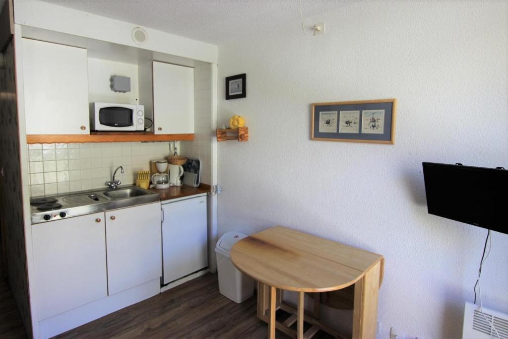 une petite cuisine avec une table et un évier dans l'établissement Résidence Roche Blanche - STUDIO 2 PERSONNES EN PLEIN CENTRE DE LA STATION MAE-7794, à Val Thorens