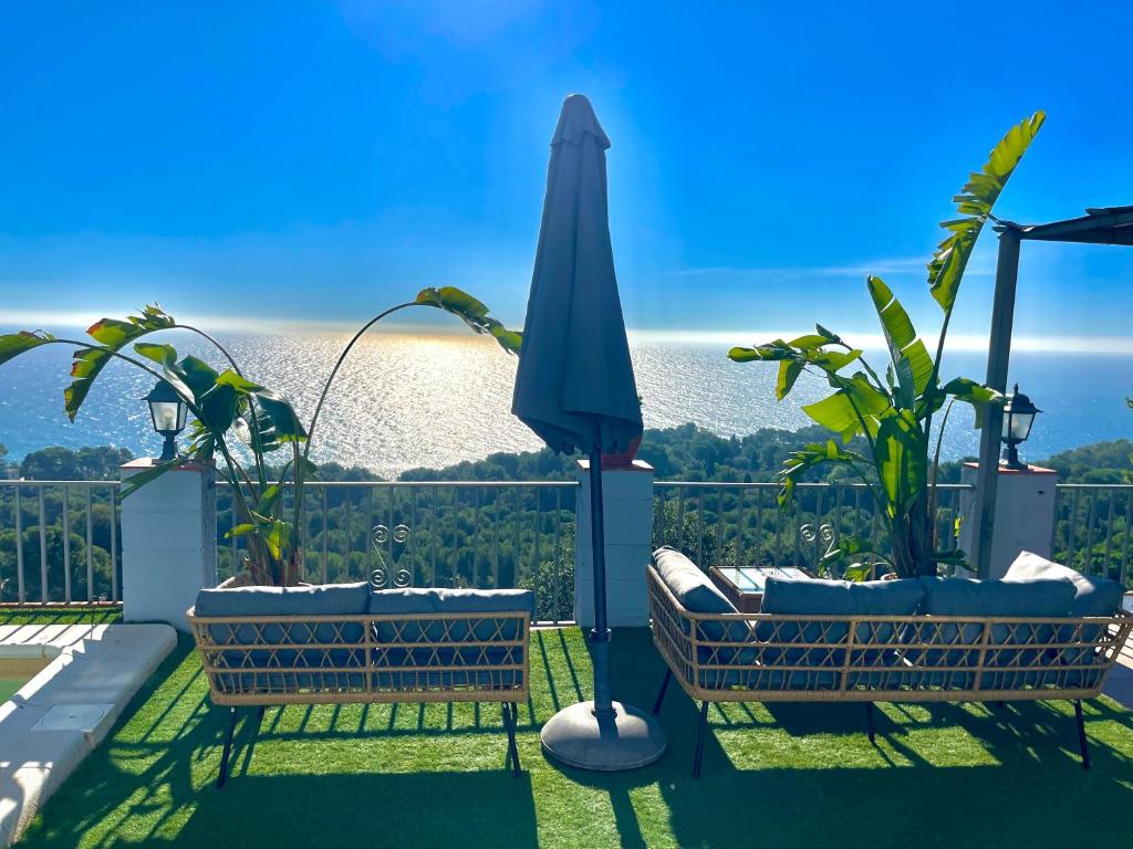 a patio with two chairs and an umbrella at SeaHomes Vacations, LA CASA BLUE Mediterranean Lifestyle in Blanes