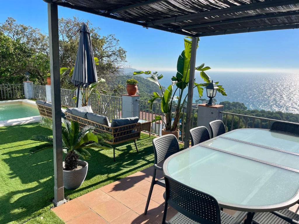 a patio with a table and chairs and the ocean at SeaHomes Vacations, LA CASA BLUE Mediterranean Lifestyle in Blanes