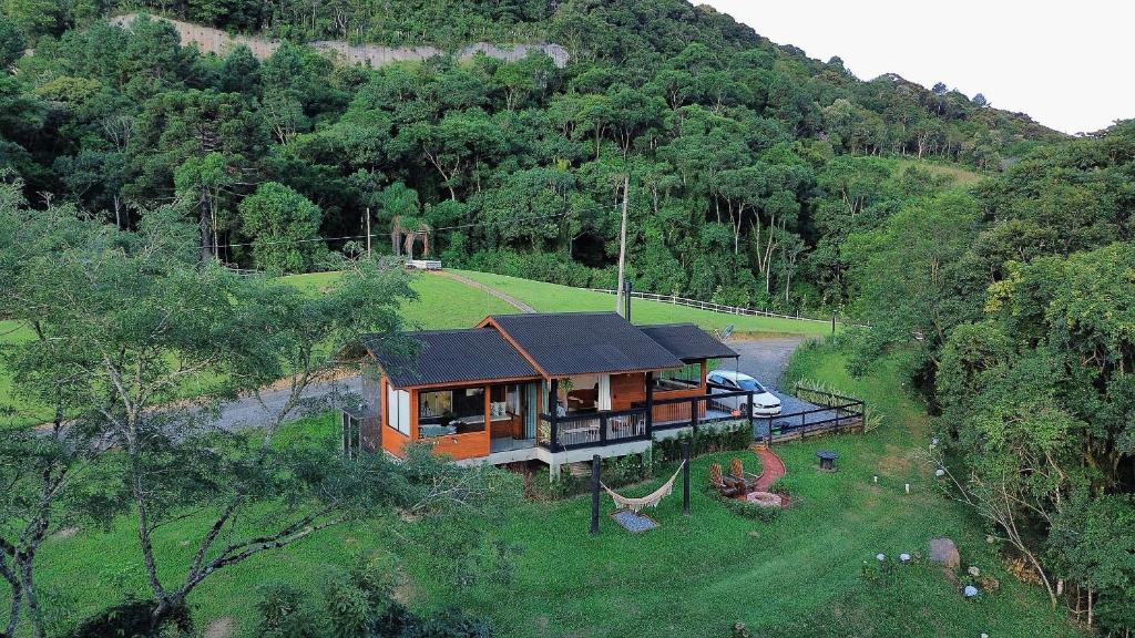a house in the middle of a field with trees at Vivenda Le Vin em Alfredo Wagner in Alfredo Wagner