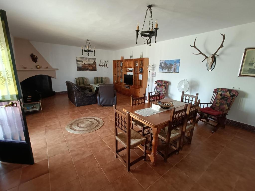 a living room with a wooden table and chairs at Casa Albahacar in Paymogo