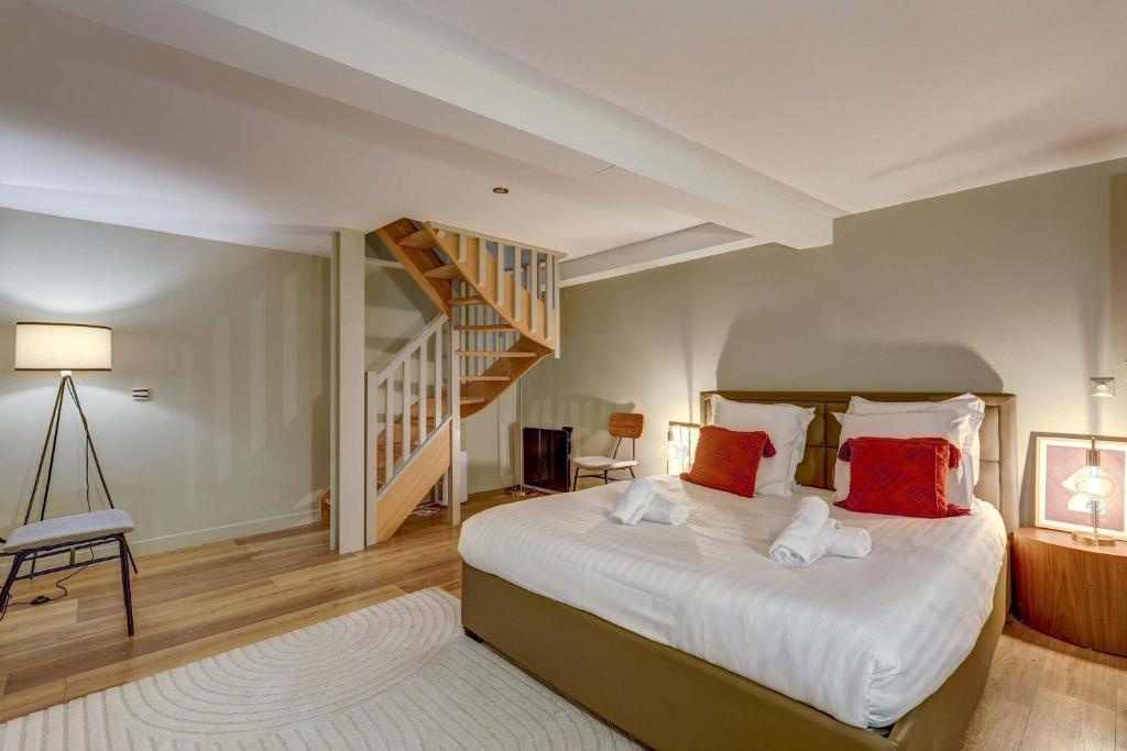 une chambre avec un grand lit et un escalier dans l'établissement Place de la Nation Cozy 2BD Duplex, à Paris