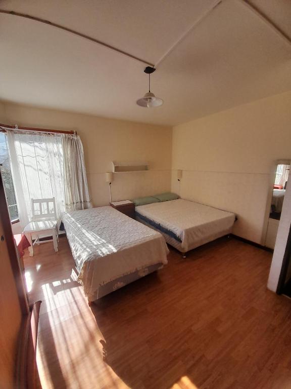 una camera da letto con due letti e una finestra di El chilco a San Carlos de Bariloche