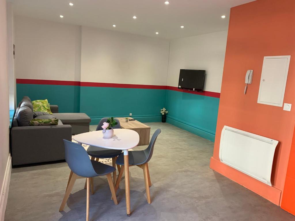 une pièce avec une table, des chaises et un canapé dans l'établissement Centre ville rdc, à Charleville-Mézières