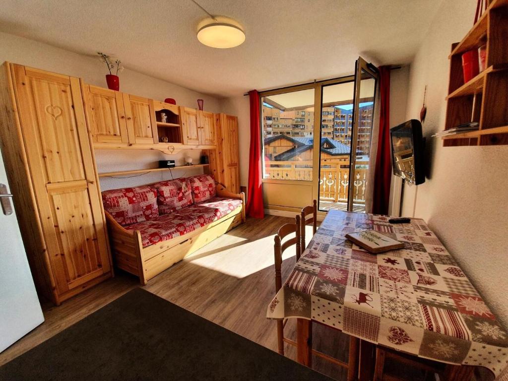 Cette petite chambre comprend un lit, une table et une fenêtre. dans l'établissement Résidence Roche Blanche - Studio pour 4 Personnes MAE-9164, à Val Thorens