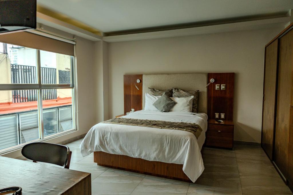 a bedroom with a large bed and a large window at JTowers in Mexico City