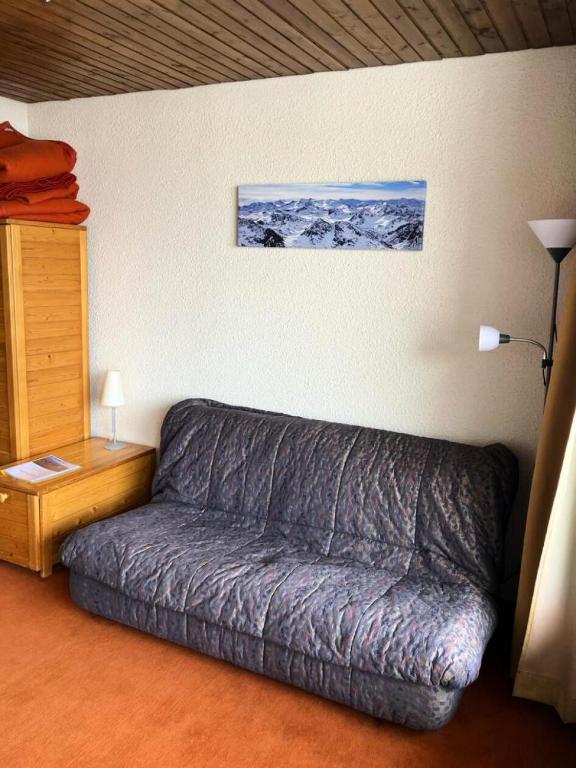 - un canapé dans le salon avec une photo sur le mur dans l'établissement Résidence Eterlous - Studio pour 4 Personnes MAE-1941, à Val Thorens