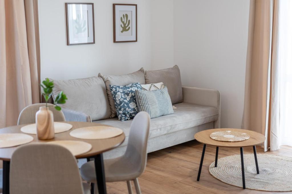 a living room with a couch and tables at LUBAVA apartment z garażem podziemnym i klimatyzacją, Netflix, TV55', winda in Lubawa