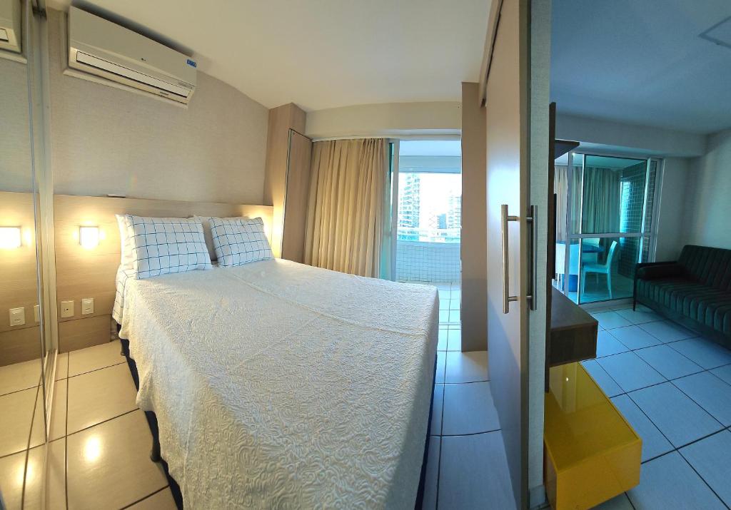 a bedroom with a large bed and a living room at Beach Class in Fortaleza
