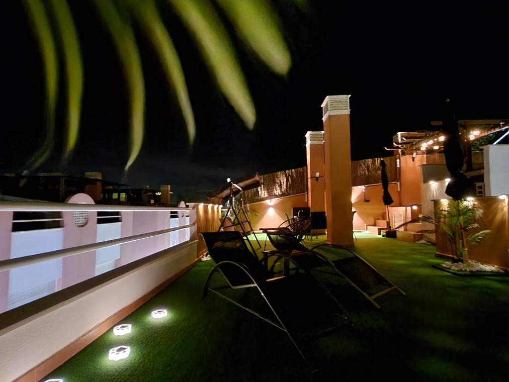 eine Dachterrasse mit Stühlen und nachts Licht in der Unterkunft Laguna Beach Relax - Terraza, Jacuzzi, Parking in Vera