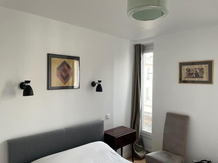 une chambre avec un lit, une chaise et une fenêtre dans l'établissement Beautiful and large apartment Paris Montparnasse, à Paris