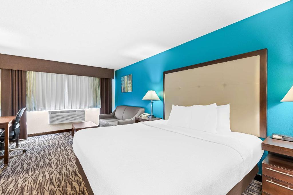 a hotel room with a large bed and blue walls at Best Western Baraboo Inn in Baraboo