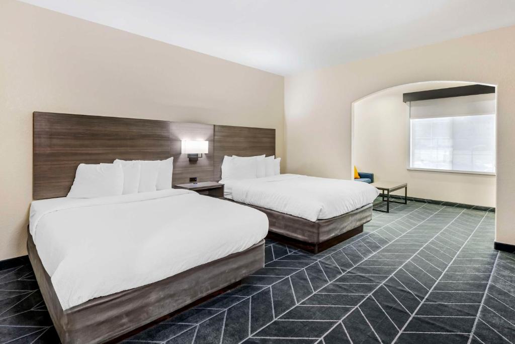 a hotel room with two beds and a desk at Best Western Lubbock West Inn & Suites in Lubbock