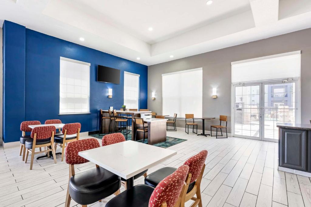 a dining room with blue walls and tables and chairs at Best Western Lubbock West Inn & Suites in Lubbock
