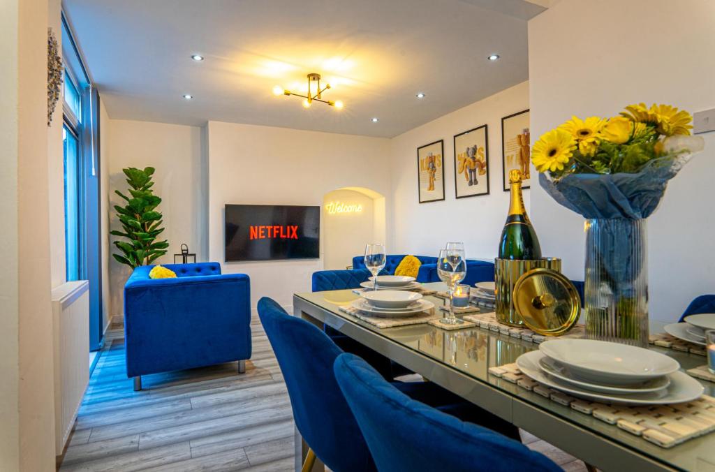 a dining room with a table and blue chairs at The Hive in Coventry