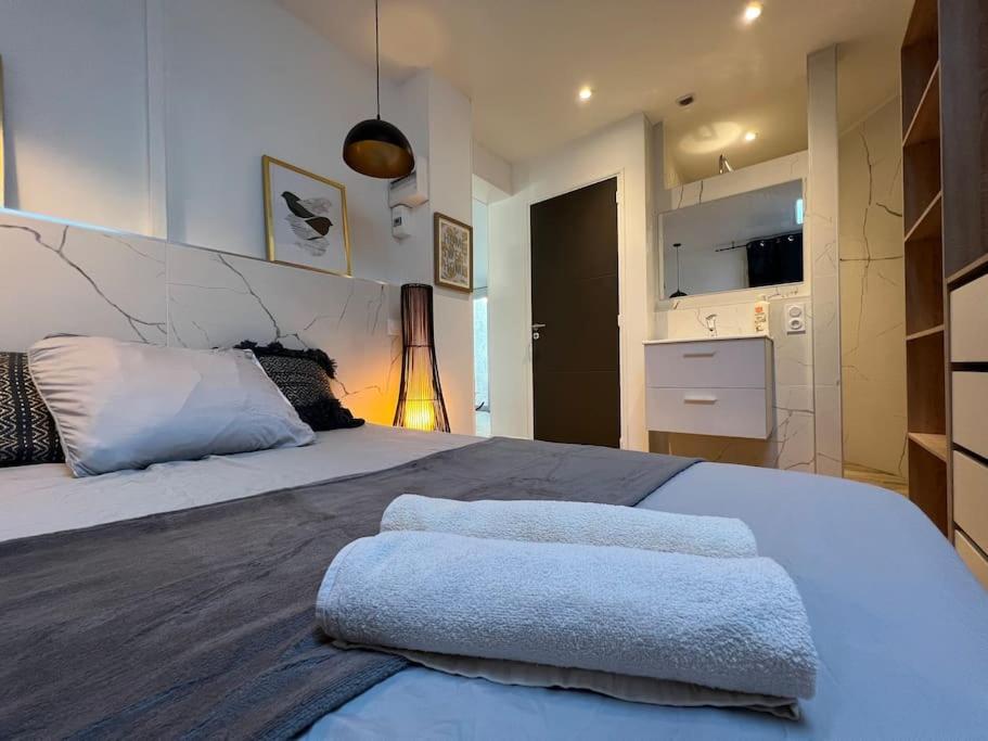une chambre avec un grand lit avec deux serviettes dessus dans l'établissement Le Duo Cosy Parking, à Carcassonne