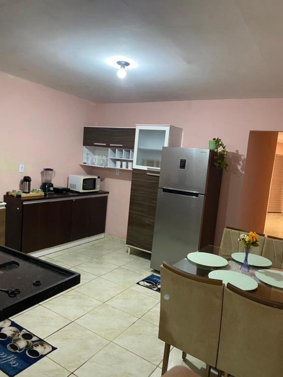 a kitchen with a table and a refrigerator at Casa Aconchegante de 2 quartos e 2 camas de casal in Juazeiro do Norte