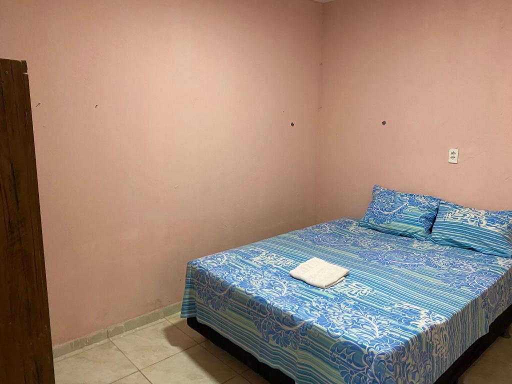 a bedroom with a bed with blue sheets and blue pillows at Casa Aconchegante de 2 quartos e 2 cama de casal e 1 de solteir in Juazeiro do Norte