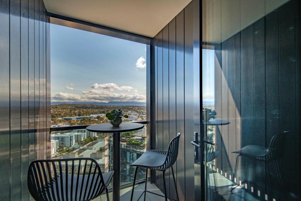 a balcony with a table and chairs in a building at Penthouse Apartment in Belconnen in Belconnen