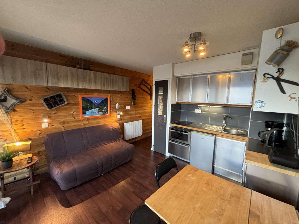 un salon avec un canapé et une cuisine dans l'établissement Studio cabine 4 couchages au pied des pistes, proche commerces - Auris en Oisans - FR-1-297-343, à Auris