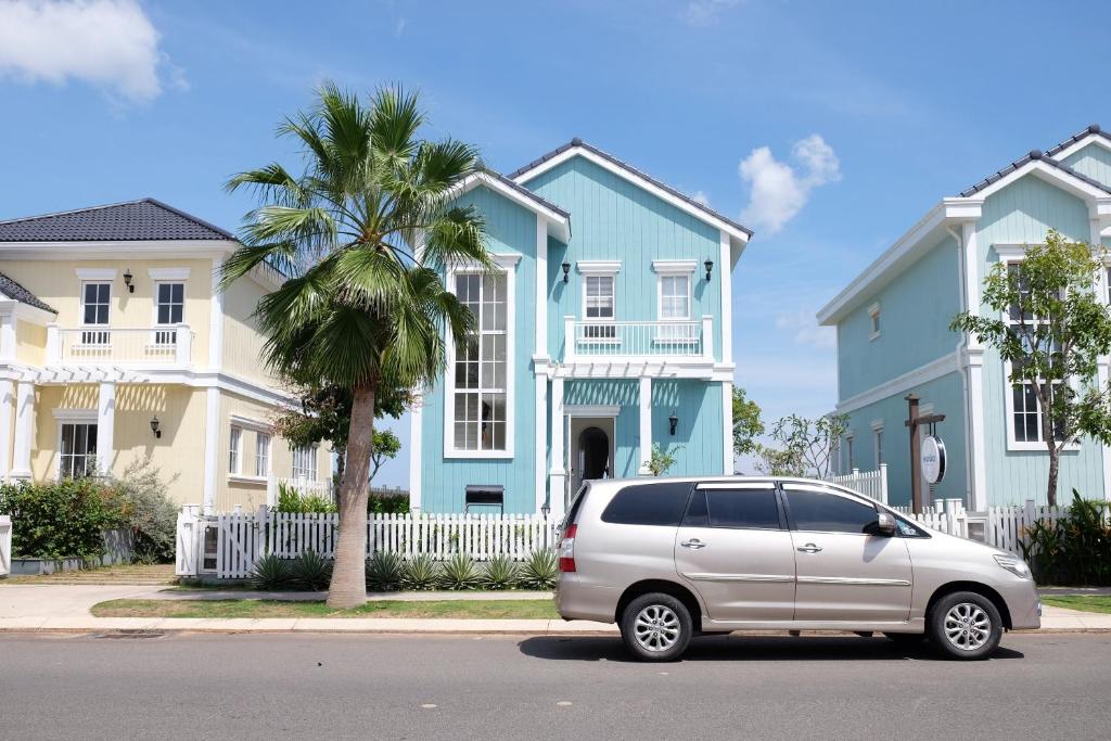 a van parked in front of a blue house at Novaworld Phan Thiết - Alala Stay in Bình Sum