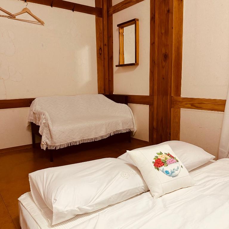 Postel nebo postele na pokoji v ubytování Jeonju Hanok village Deoksugung