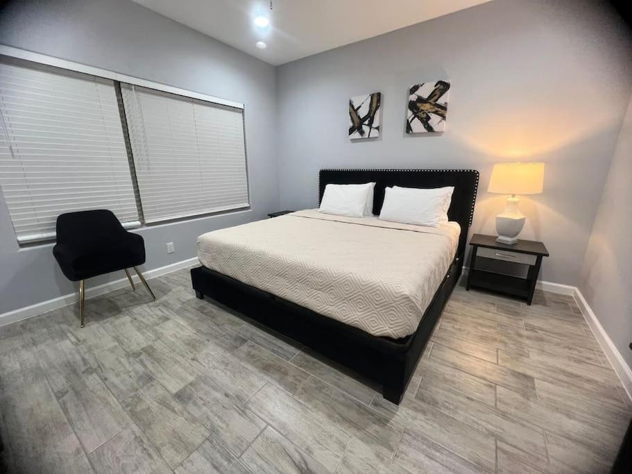 a bedroom with a bed and a chair and a window at South Texas Getaway King Size & Double Queen in Brownsville