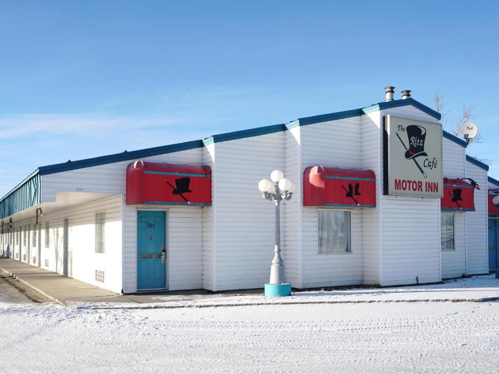 a building with red signs on the side of it at The Ritz Cafe and Motor Inn in Whitecourt