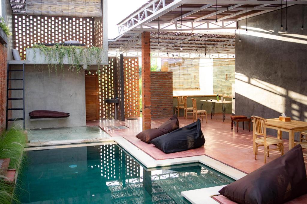 patio z basenem, stołem i krzesłami w obiekcie Dedeane Hotel & Yoga Retreat w mieście Ubud