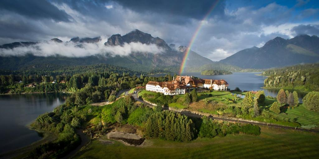 Llao Llao Resort, Golf-Spa في سان كارلوس دي باريلوتشي: قزاز فوق منزل على تلة بجوار بحيرة