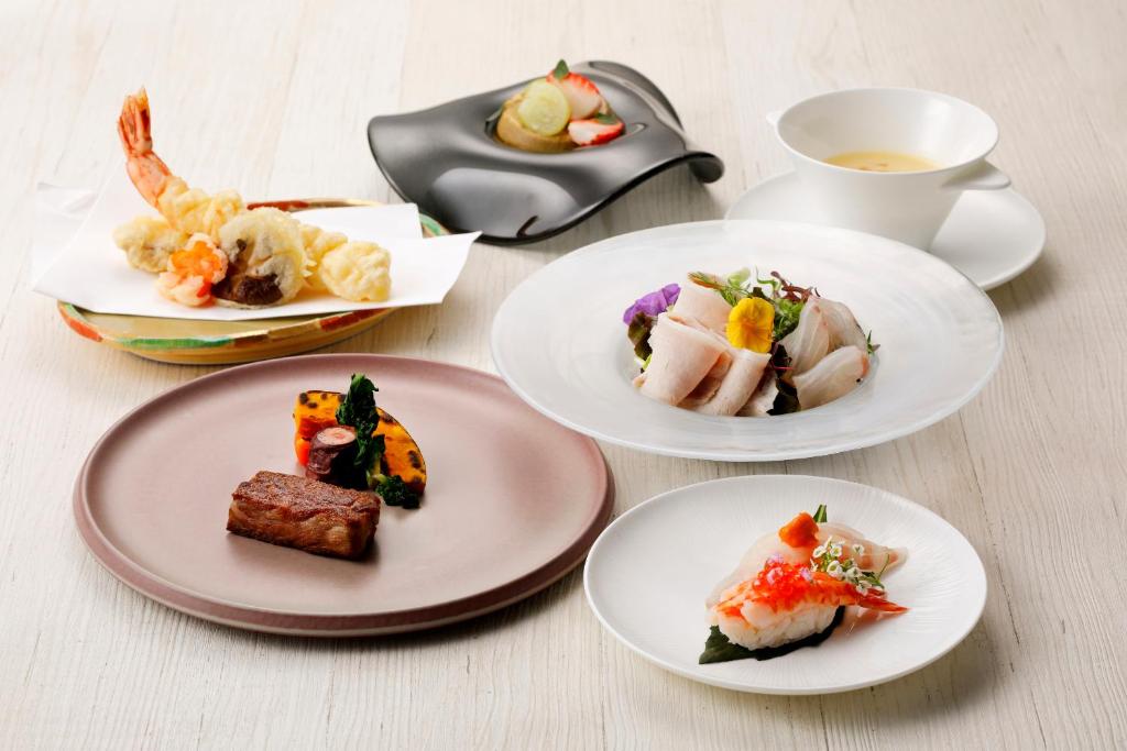 four plates of food on a table with a cup of tea at THE HOTEL SANRAKU KANAZAWA 21th December 2022 OPEN in Kanazawa