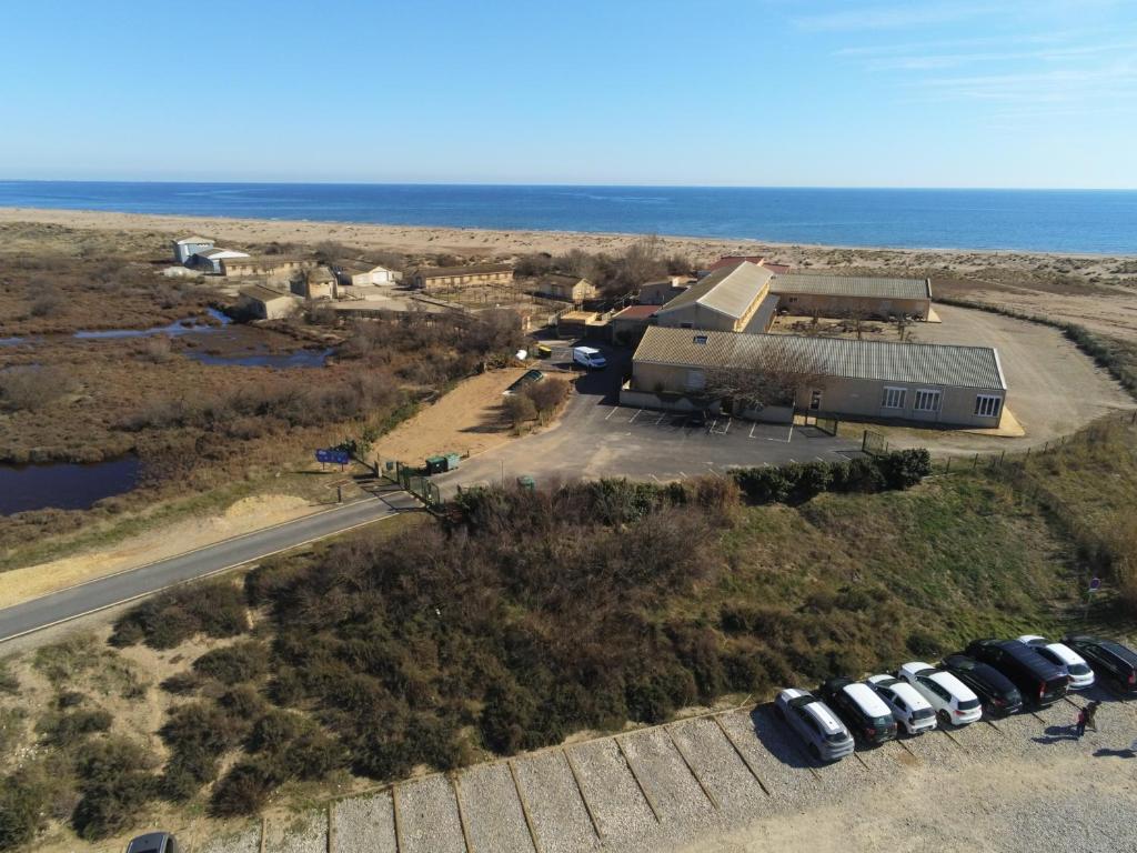- une vue aérienne sur une maison avec des voitures garées à côté de l'océan dans l'établissement Mer Et Soleil, à Valras-Plage