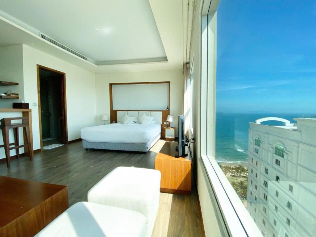 ein Schlafzimmer mit Bett und Blick auf das Meer in der Unterkunft COZY Studio in A La Carte Da Nang in Đà Nẵng